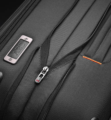 Close-up of a black suitcase with zipper expansion