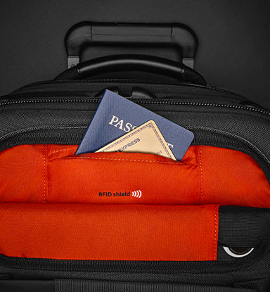 Black suitcase with a orange RFID shield pocket containing a passport and card.