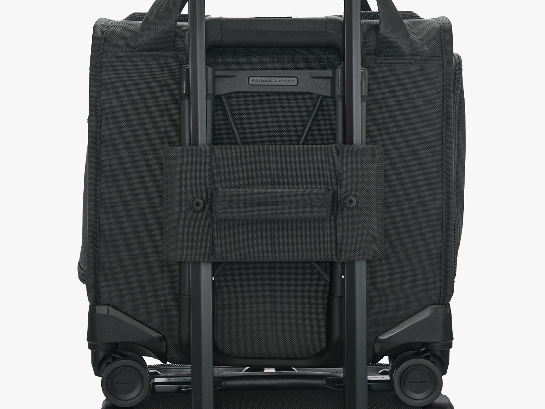 The Briggs & Riley Baseline 2-Wheel Cabin Bag's interlocking handle system locking into a carry-on handle.