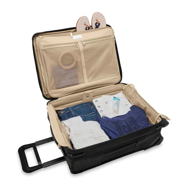 The Briggs & Riley Baseline 21" 2-Wheel Expandable Carry-On is filled with clothes for an extended vacation. All the clothes are neatly organized in each compartment.  #color_black