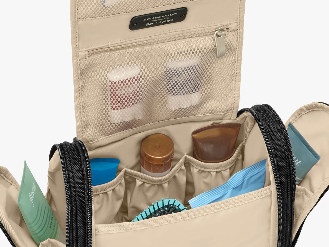 Inside the Briggs & Riley Baseline Deluxe Hangable Kit, the large main pocket has toiletries and a comb, while the upper PVC-lined pocket stores two travel-size deodorants; the two side compartments each store one tube-shaped toiletry.
