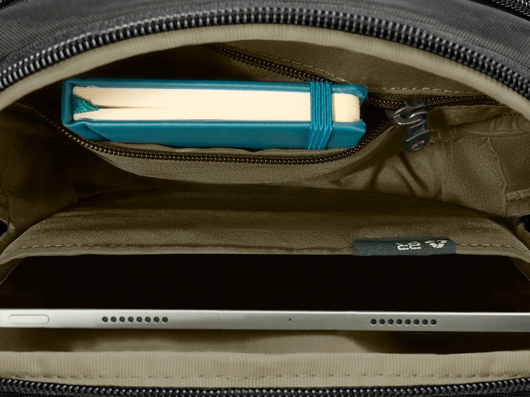 Interior view of the Briggs & Riley HTA Crossbody Bag; inside, we see an iPad safely stored in the tablet slip pocket and a notebook with room to spare.